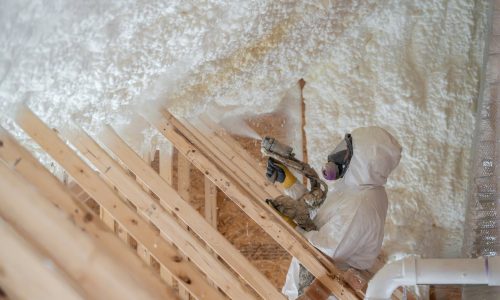 construction worker spraying house insulation